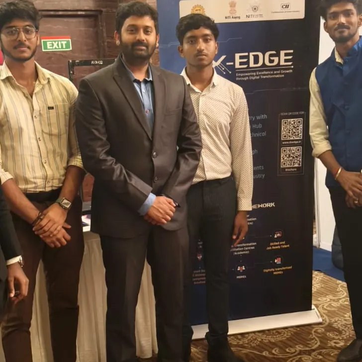 Three attendees pose in front of a DX-EDGE event backdrop.